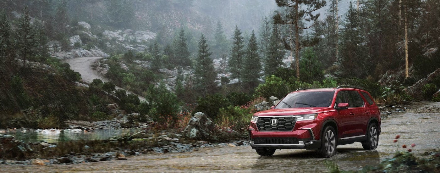 A red 2025 Honda Pilot from the front at an angle.