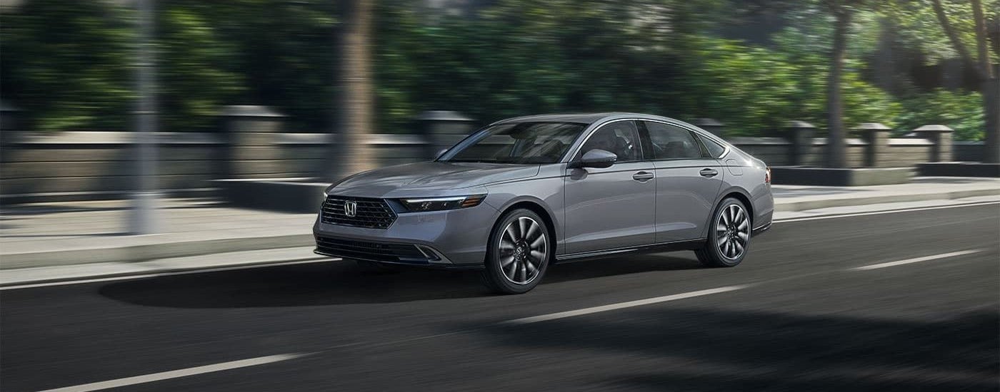 Silver 2023 Honda Accord Hybrid driving on an open road