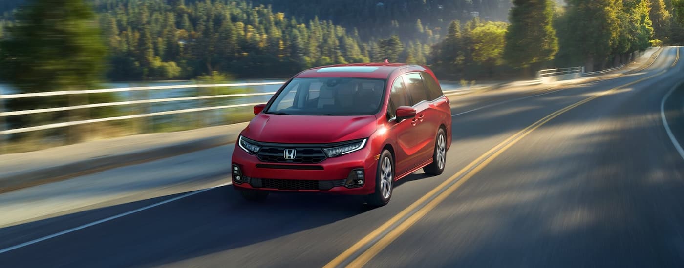 Red 2026 Honda Odyssey driving on an open road