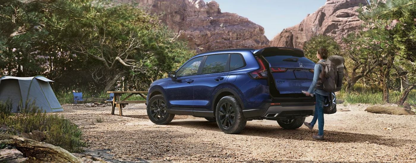 Blue 2026 Honda CR-V parked at a campsite with a man using the foot activated LiftGate.