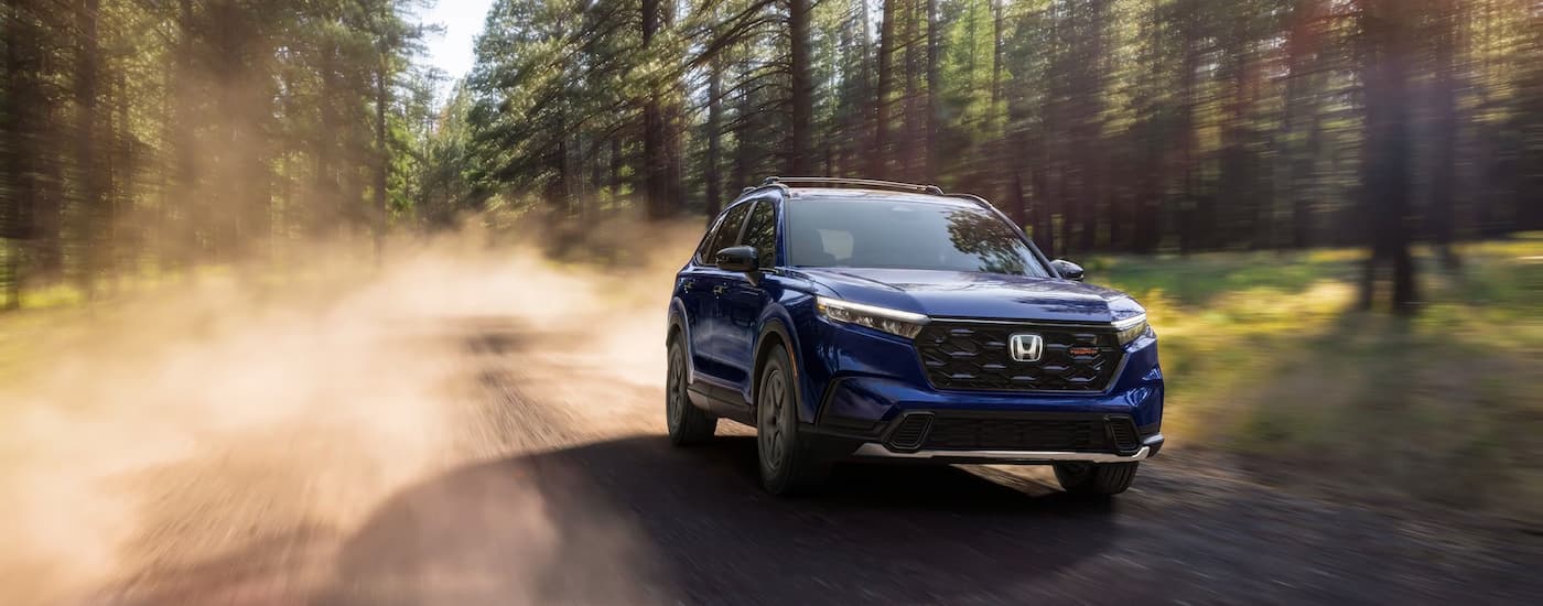 Blue 2026 Honda CR-V driving on a dirt road