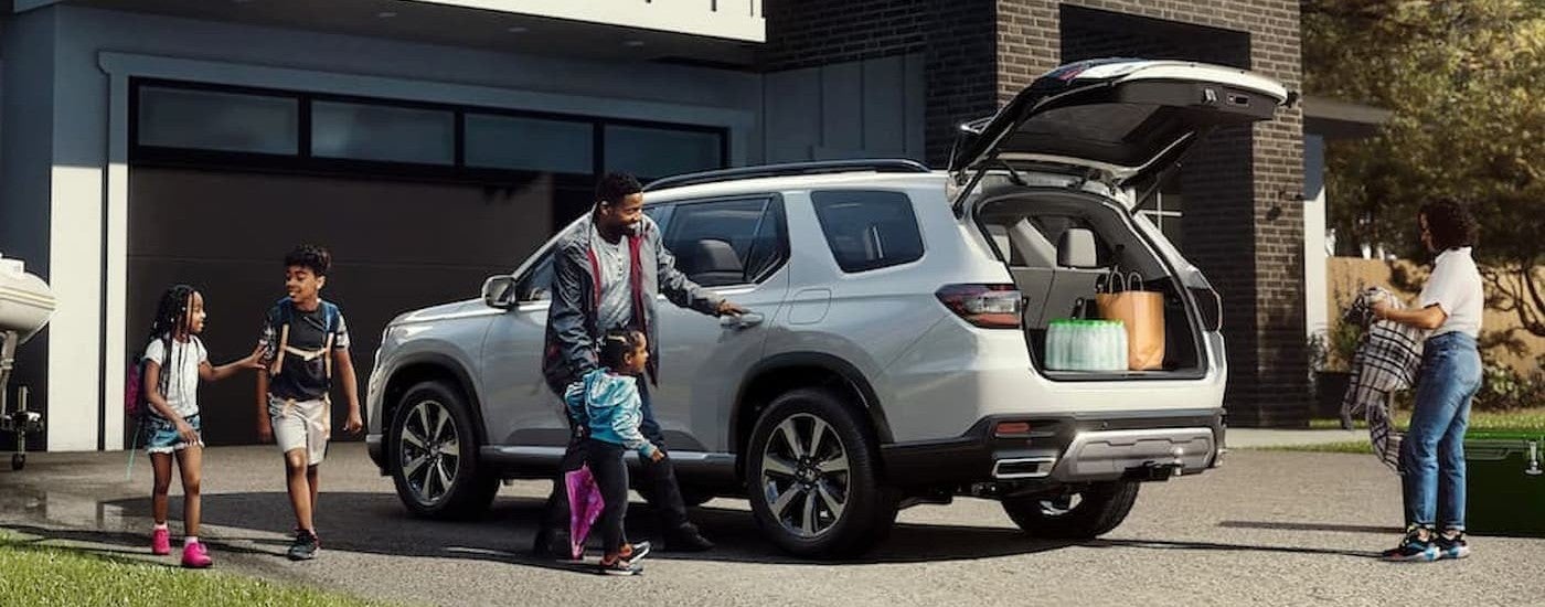 A white 2025 Honda Pilot parked on a driveway.